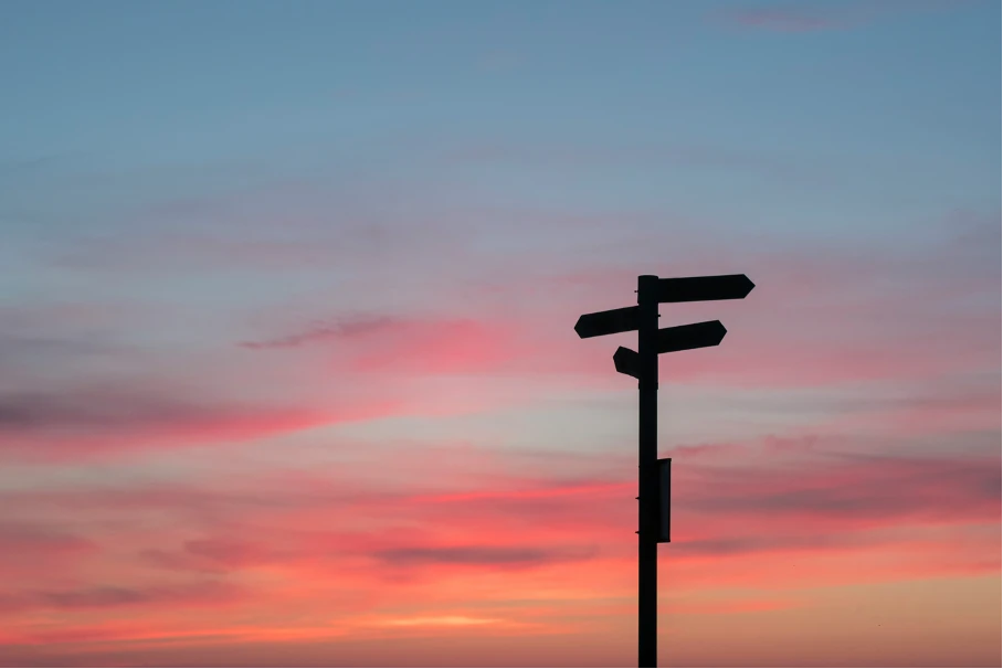 Richtungsweiser bei Sonnenuntergang als Symbol für Veränderungen